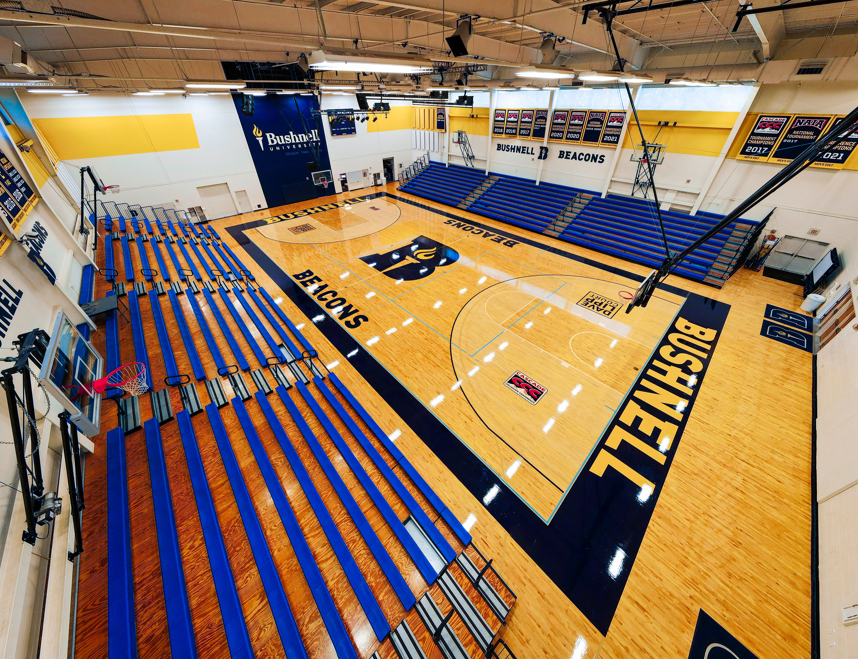 Overhead photo showing off the Bushnell basketball court in the Morse Center with wood polished floors and athletic logo in the center.