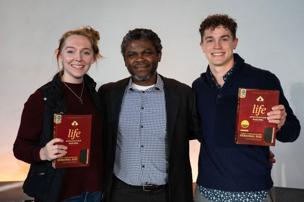 Bushnell University students and faculty pose with Life Application Study Bibles during a campus event.