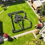 Aerial view of Bushnell University students and employees forming the Bushnell torch on the campus lawn.
