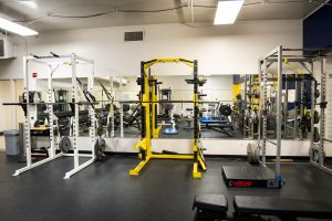 Power racks and free-weight stations inside Bushnell University's Fitness Center.
