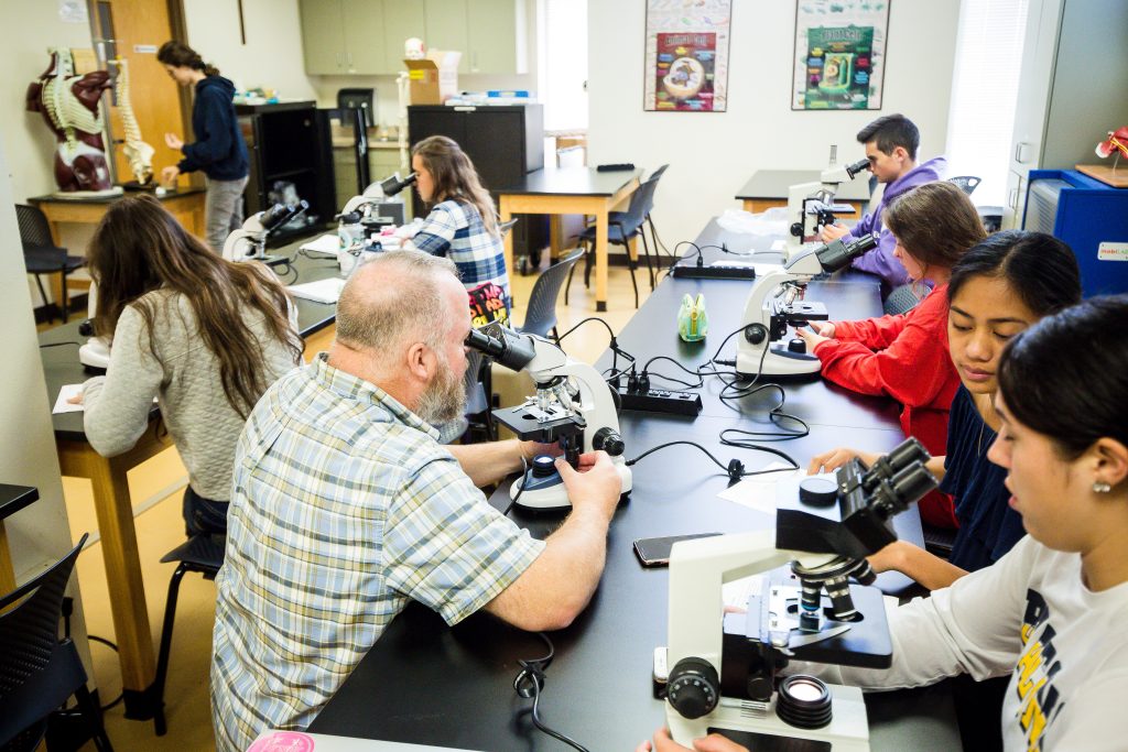 Bushnell University biology students use microscopes during a laboratory class.