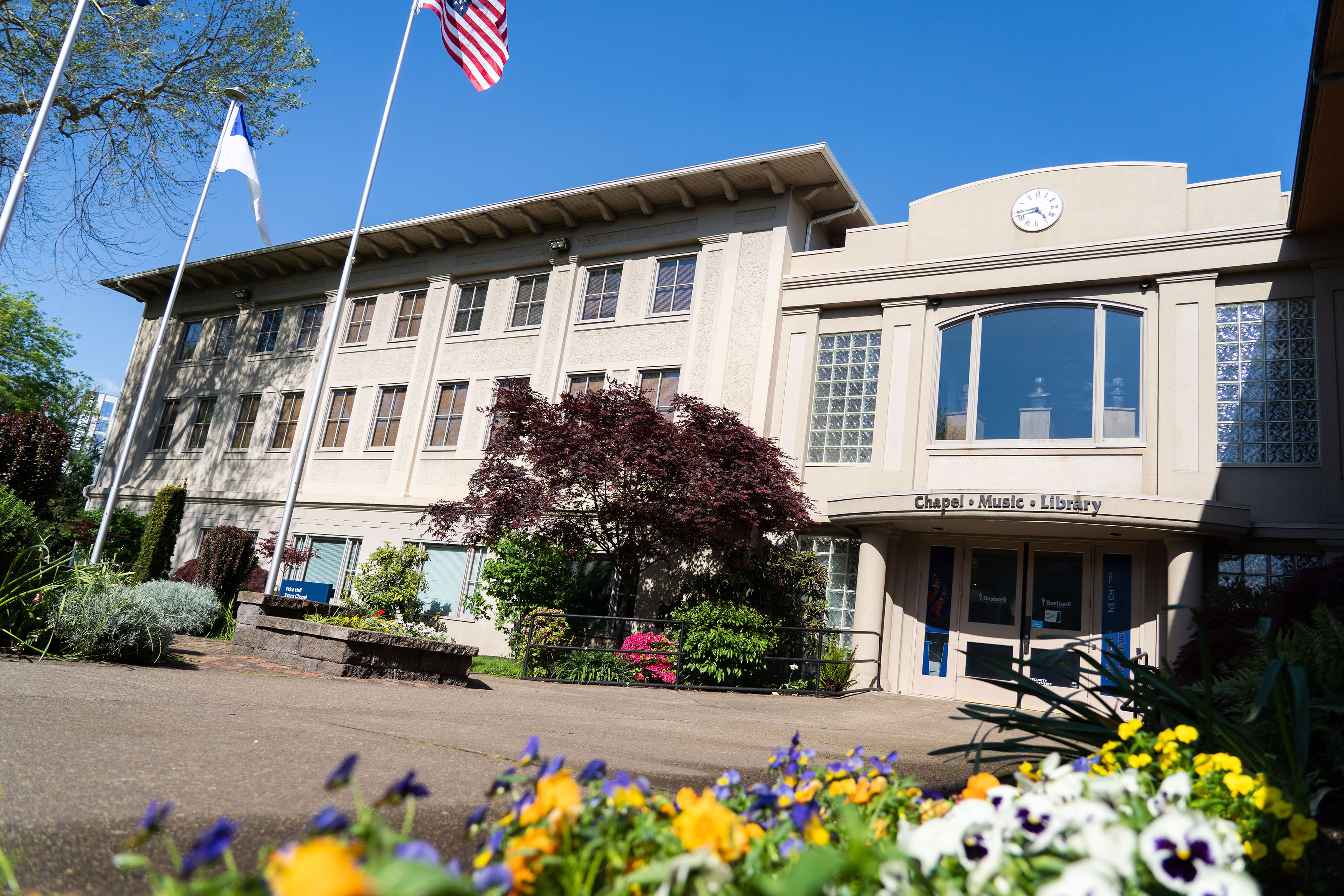 Exterior photo of grey and cream building on a sunny day on Bushnell campus.