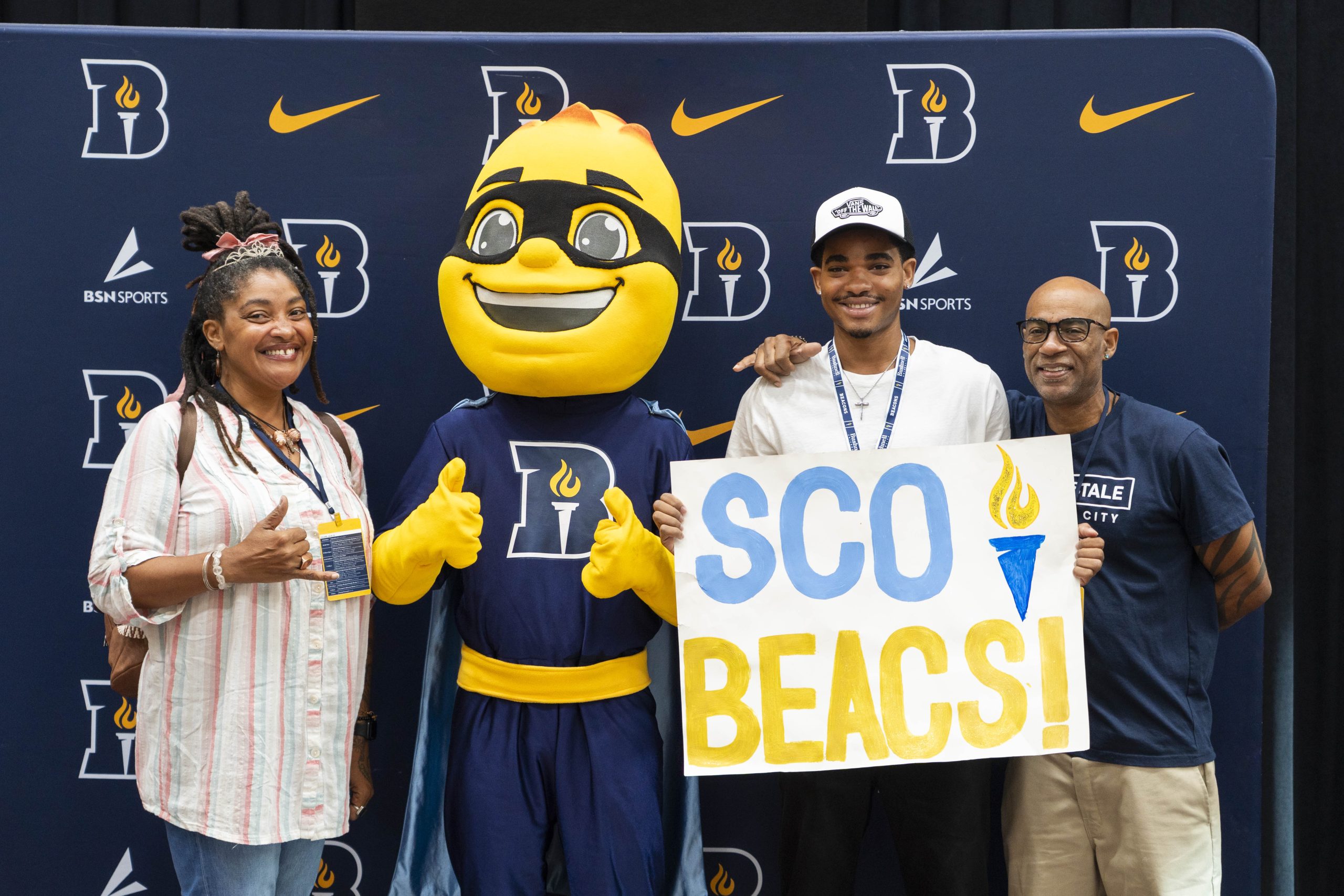 A new student and their family pose with Bushnell University mascot, Iggy Beacon, at Orientation.