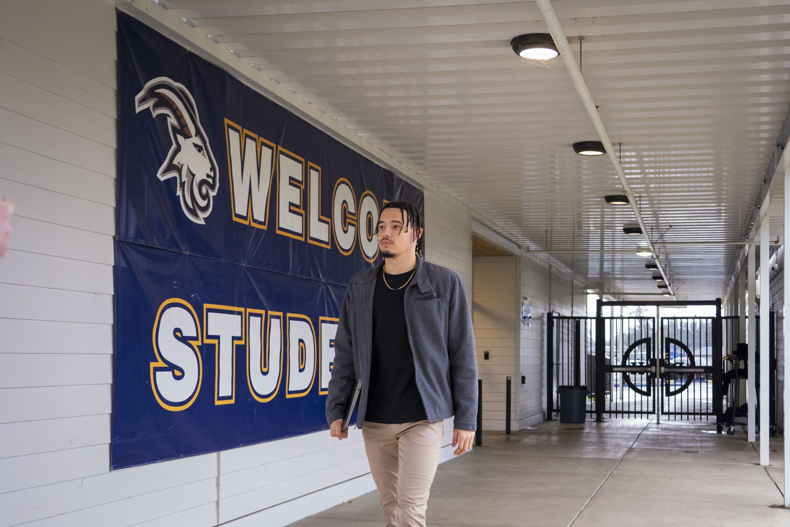 Bushnell University student walking through the athletics complex carrying a laptop.