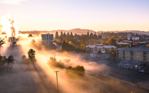 Sunrise over Bushnell University's campus in Eugene, Oregon, with morning fog and autumn trees.