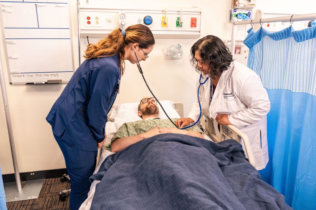 Bushnell University nursing student and faculty member assess a patient during a clinical simulation.