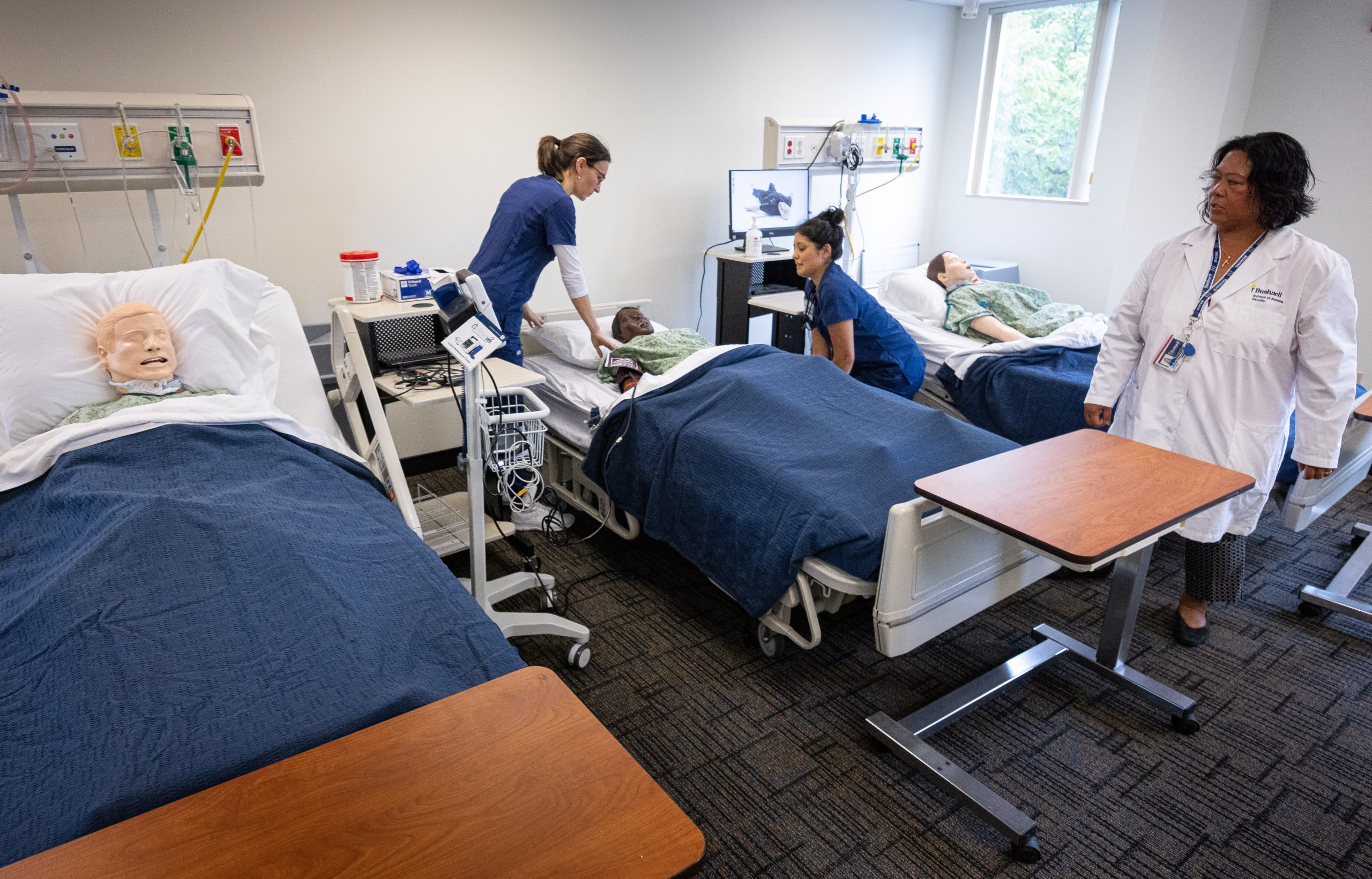 Bushnell University nursing students participate in a clinical simulation exercise with faculty guidance in the simulation lab.