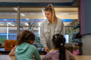 Bushnell University student working with elementary school students during field experience.