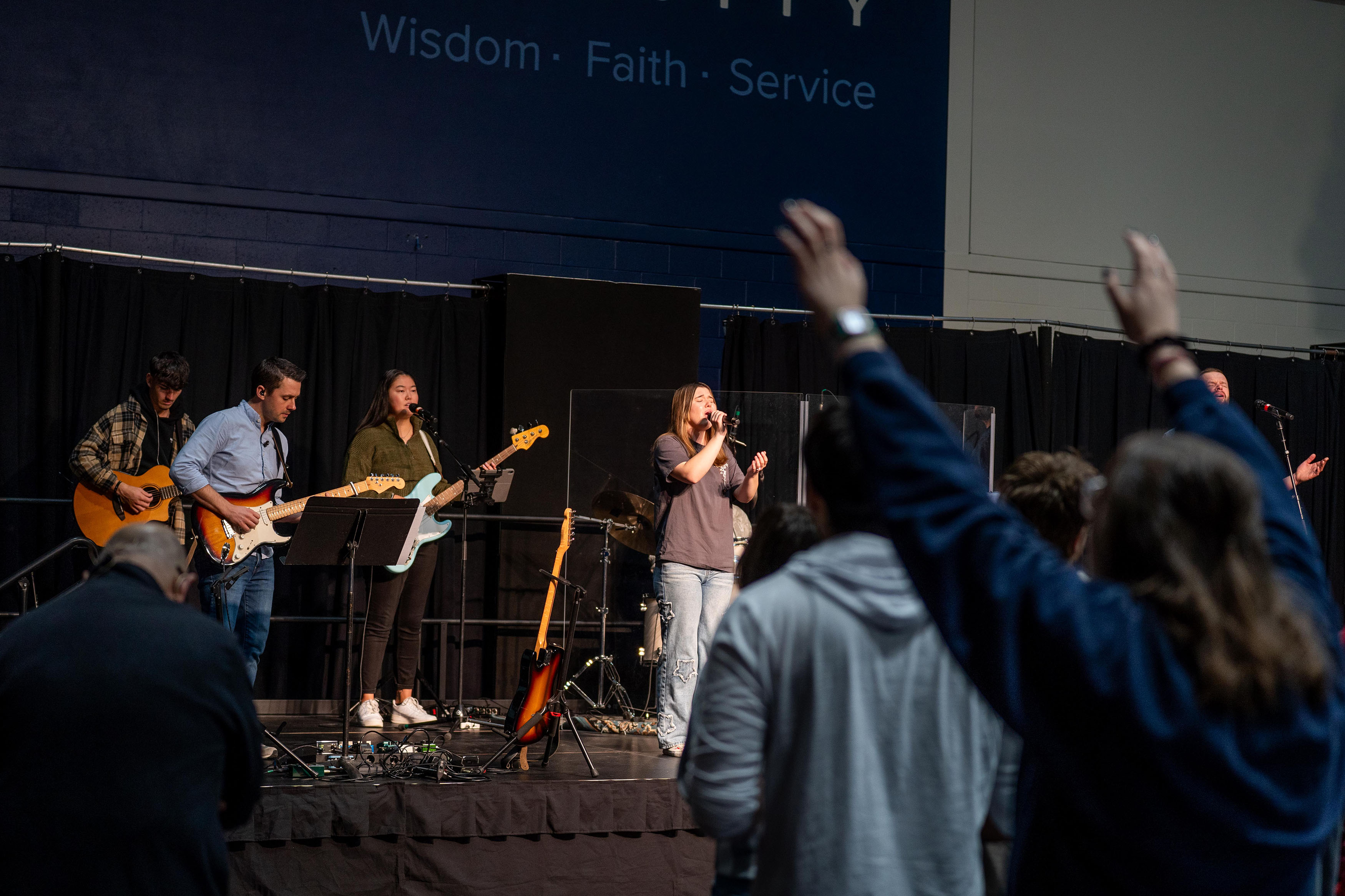 Bushnell Chapel worship band on stage performing Christian songs to audience of students.