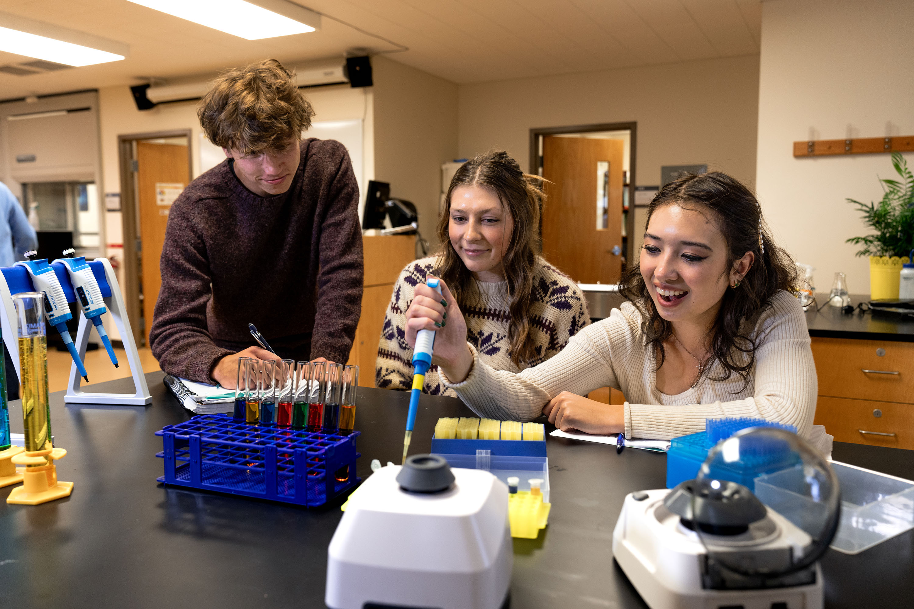 Students perform tasks within a chemistry lab.