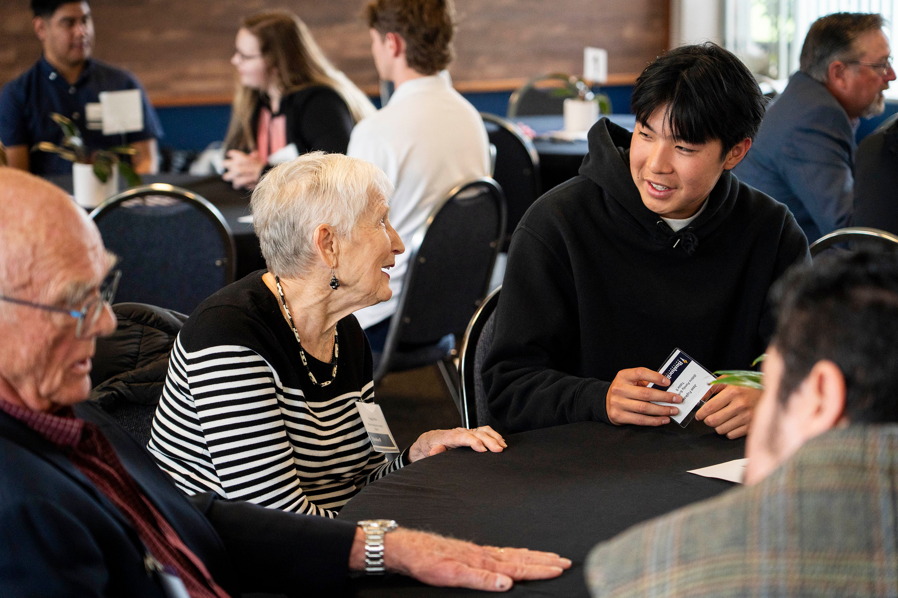 A scholarship donor and student benefitting from scholarships chat during a luncheon event.