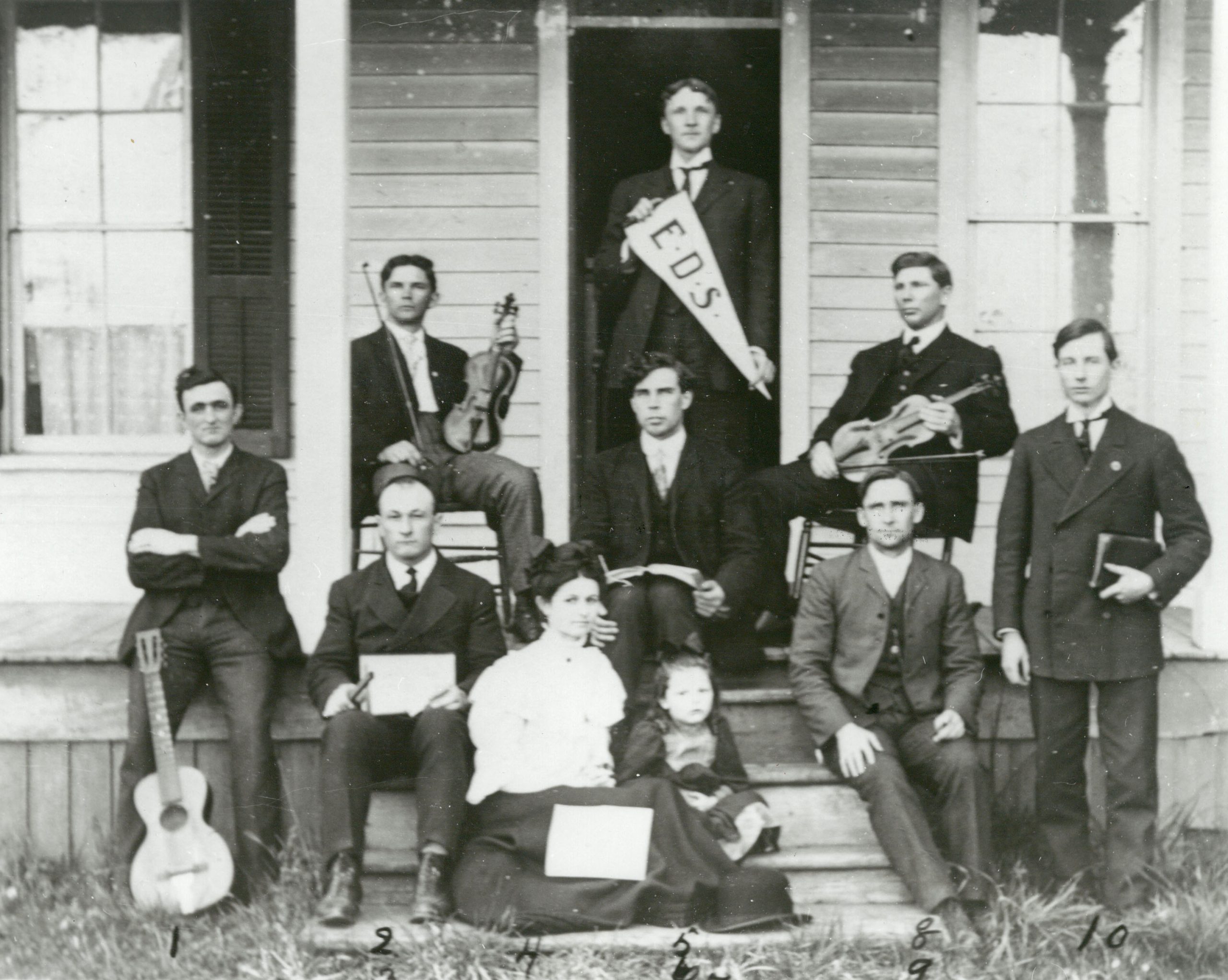 Historical photo of a Eugene Divinity School class of well dressed men with one holding an EDS pennant.