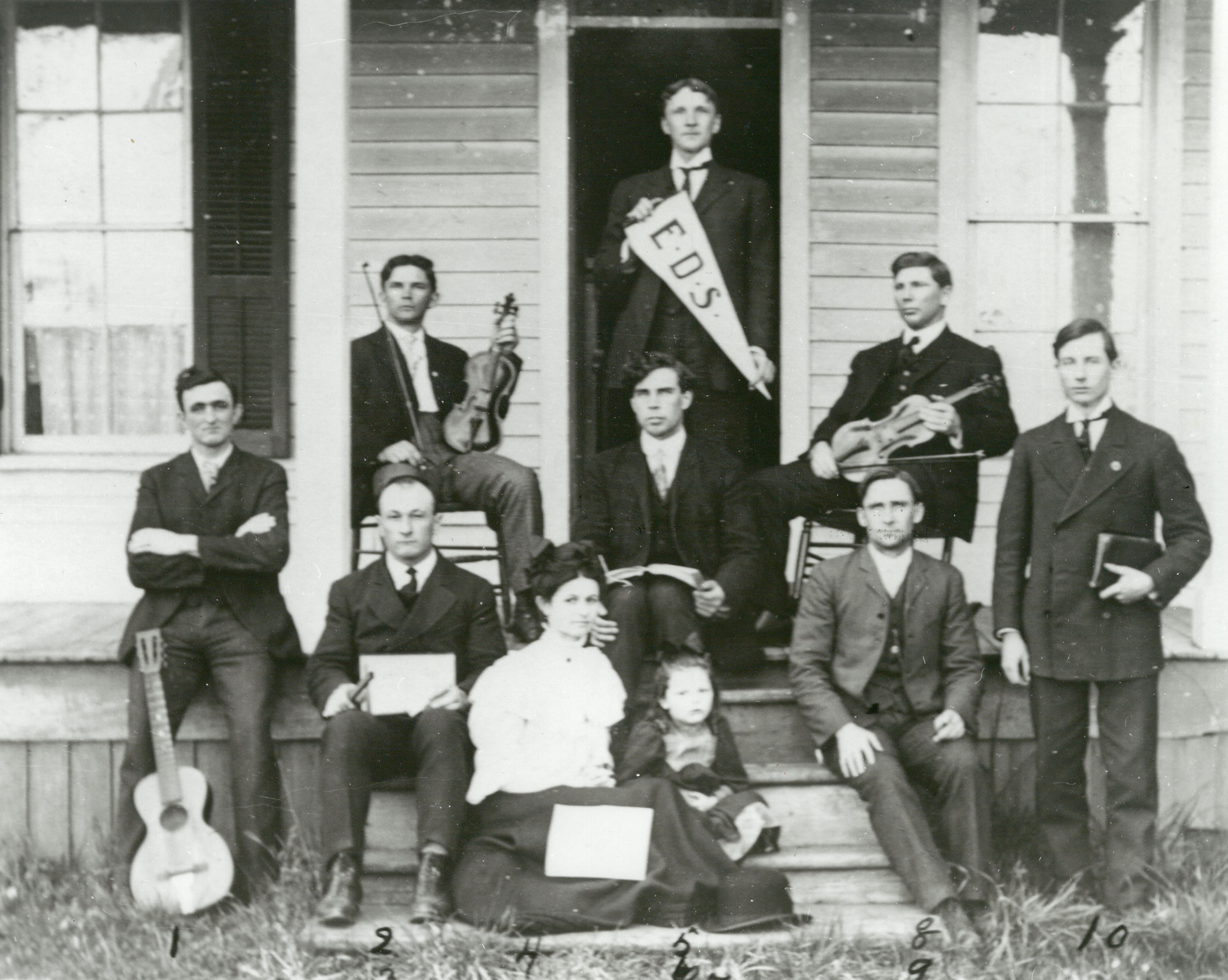 Historical photo of a Eugene Divinity School class of well dressed men with one holding an EDS pennant.