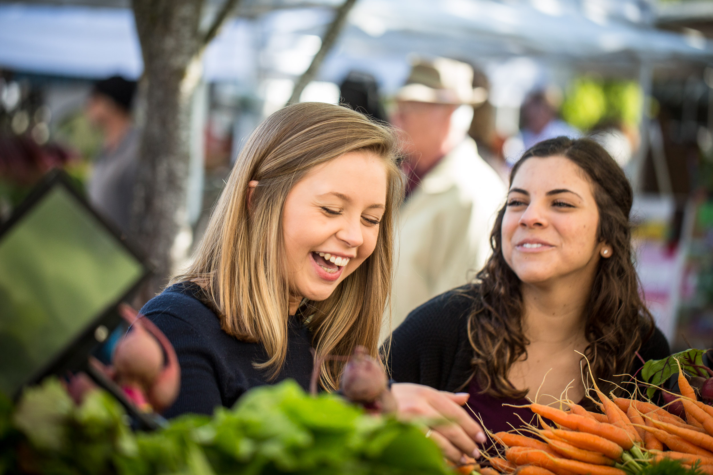 Students looking at fresh vegetables while visiting the Eugene Farmers Market.