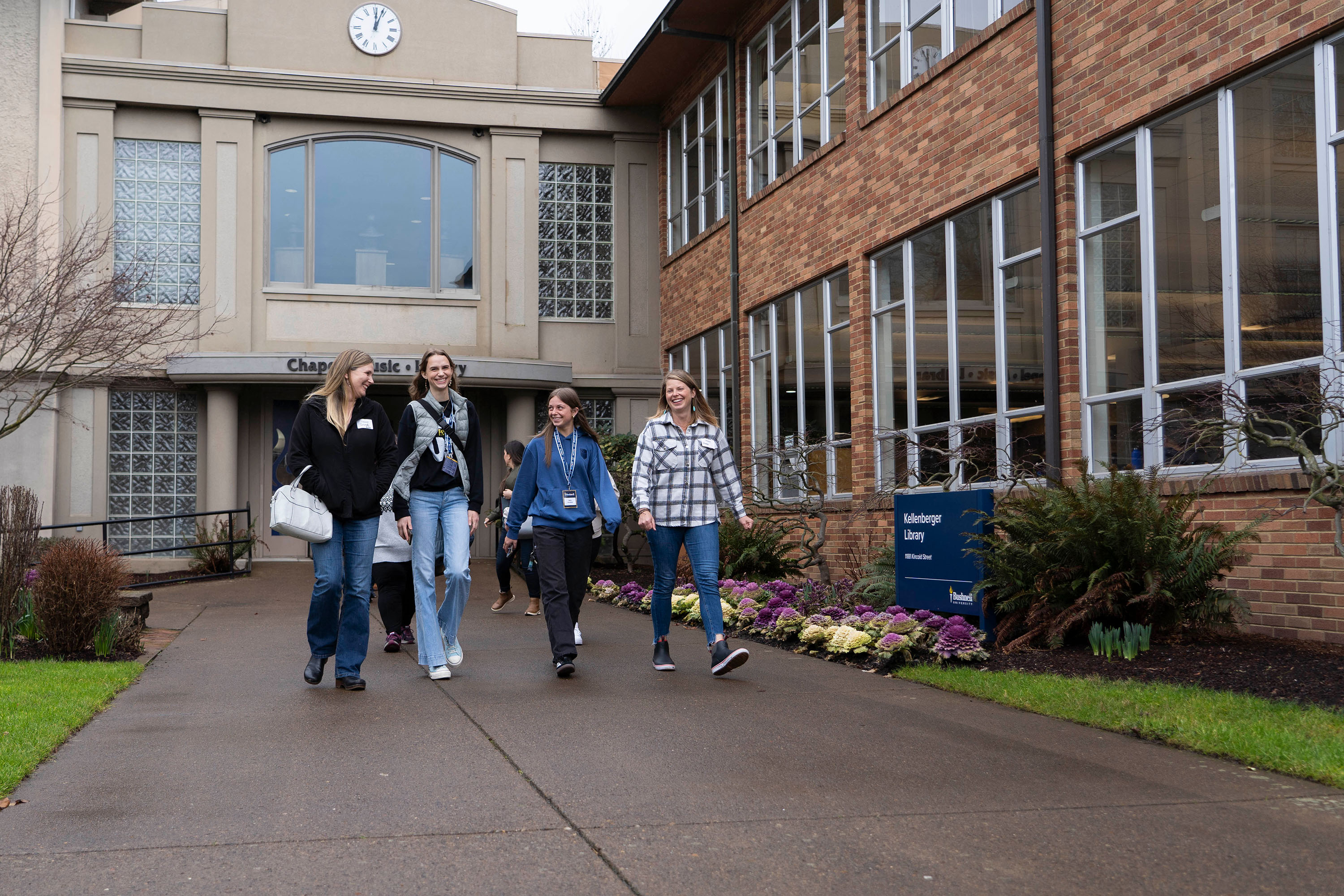 A tour group smiling during a Bushnell University campus tour in front of the library building.