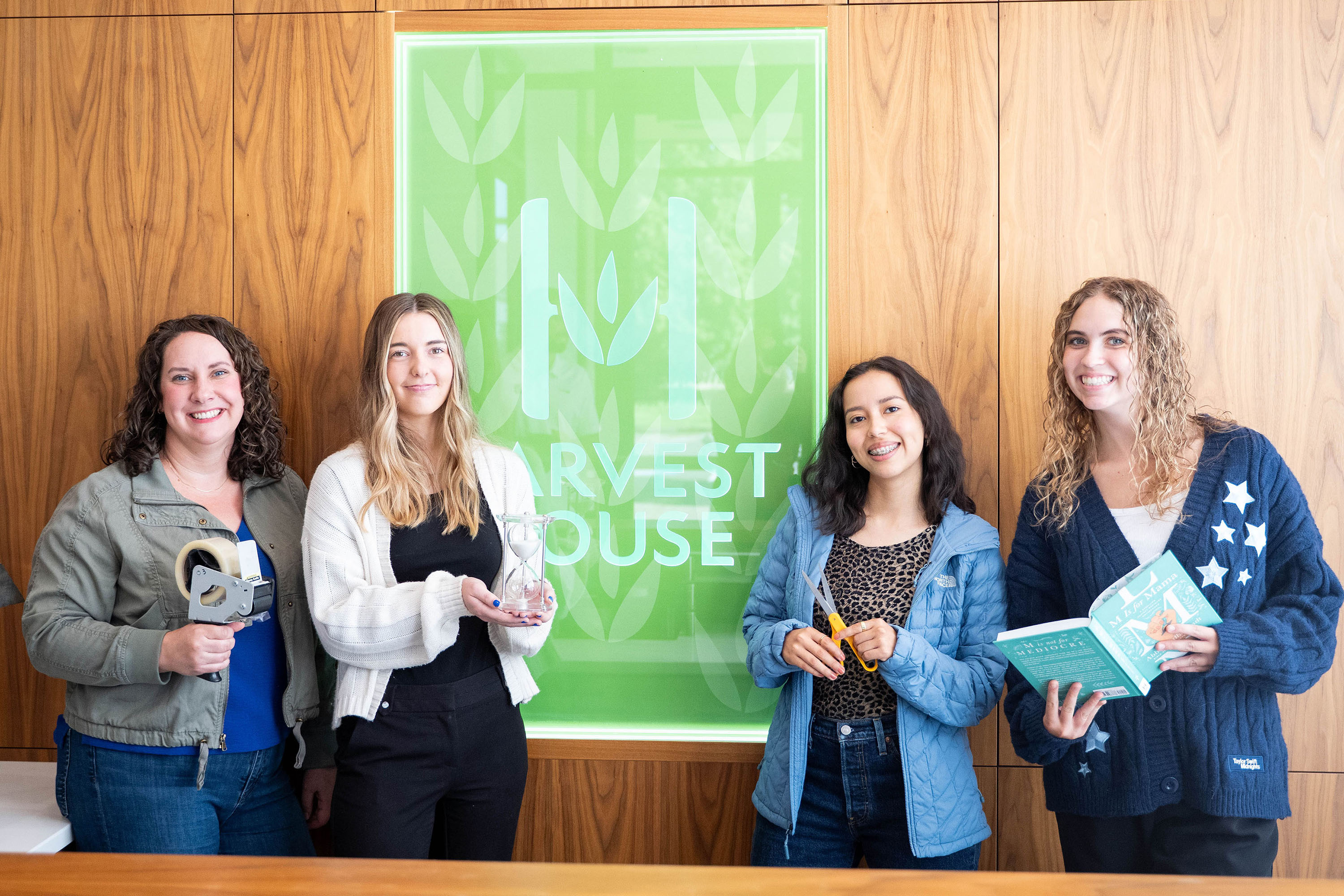 Harvest house student interns pose with supervisor while holding office supplies.