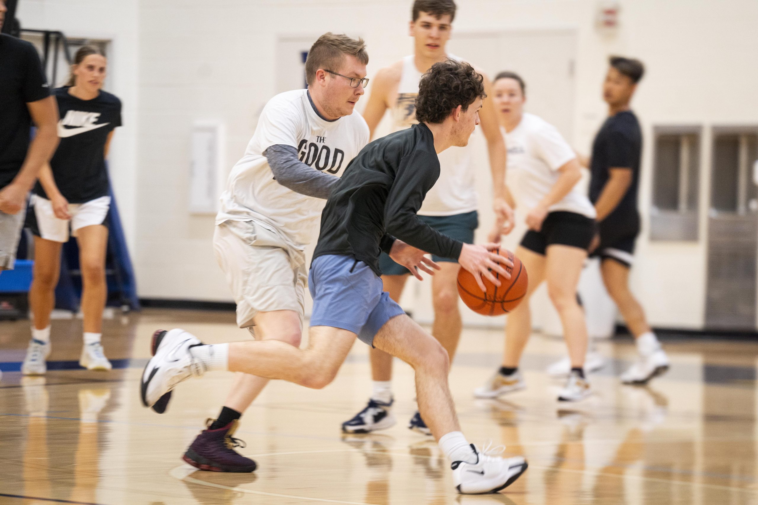 Men and women's intramural basketball action photo as a student dribbles the ball down the court.