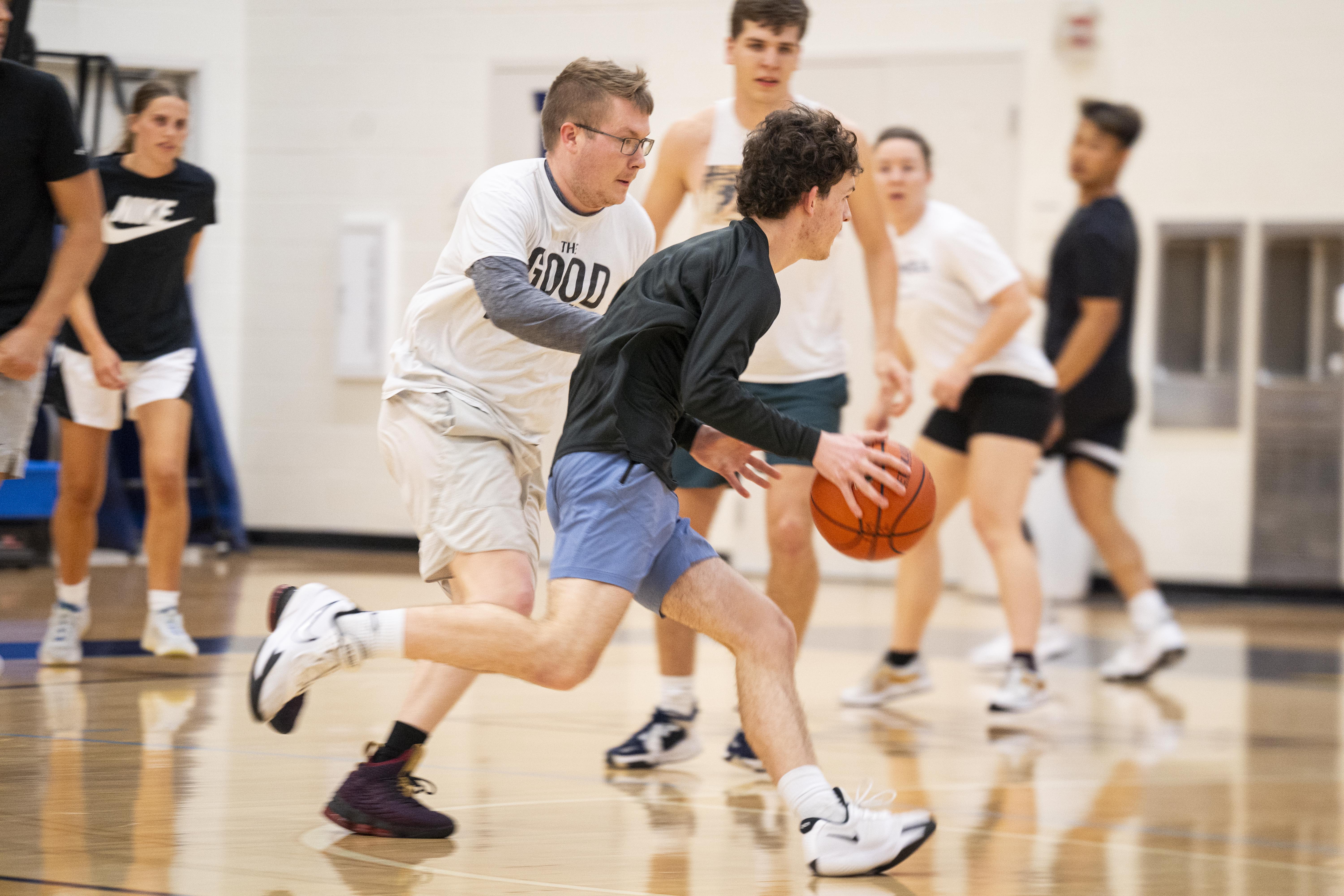Men and women's intramural basketball action photo as a student dribbles the ball down the court.
