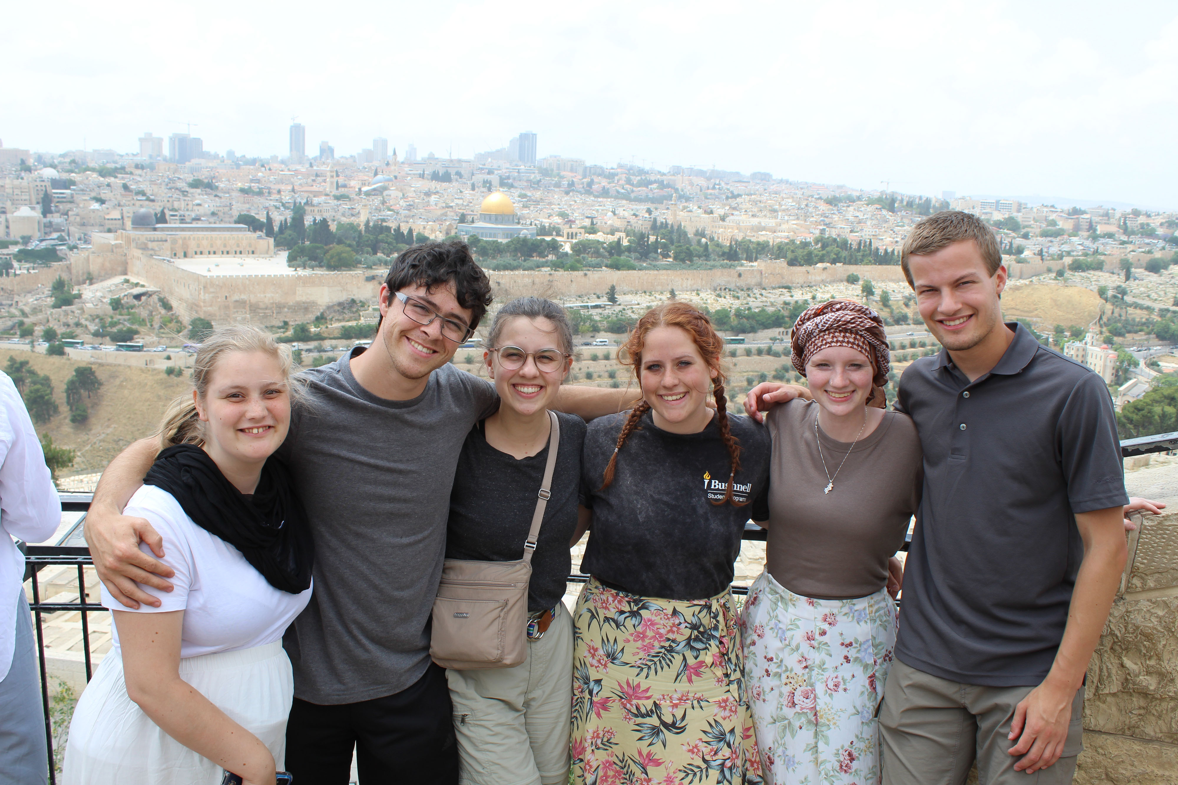 A group of students pose with a view of Israel in the background.