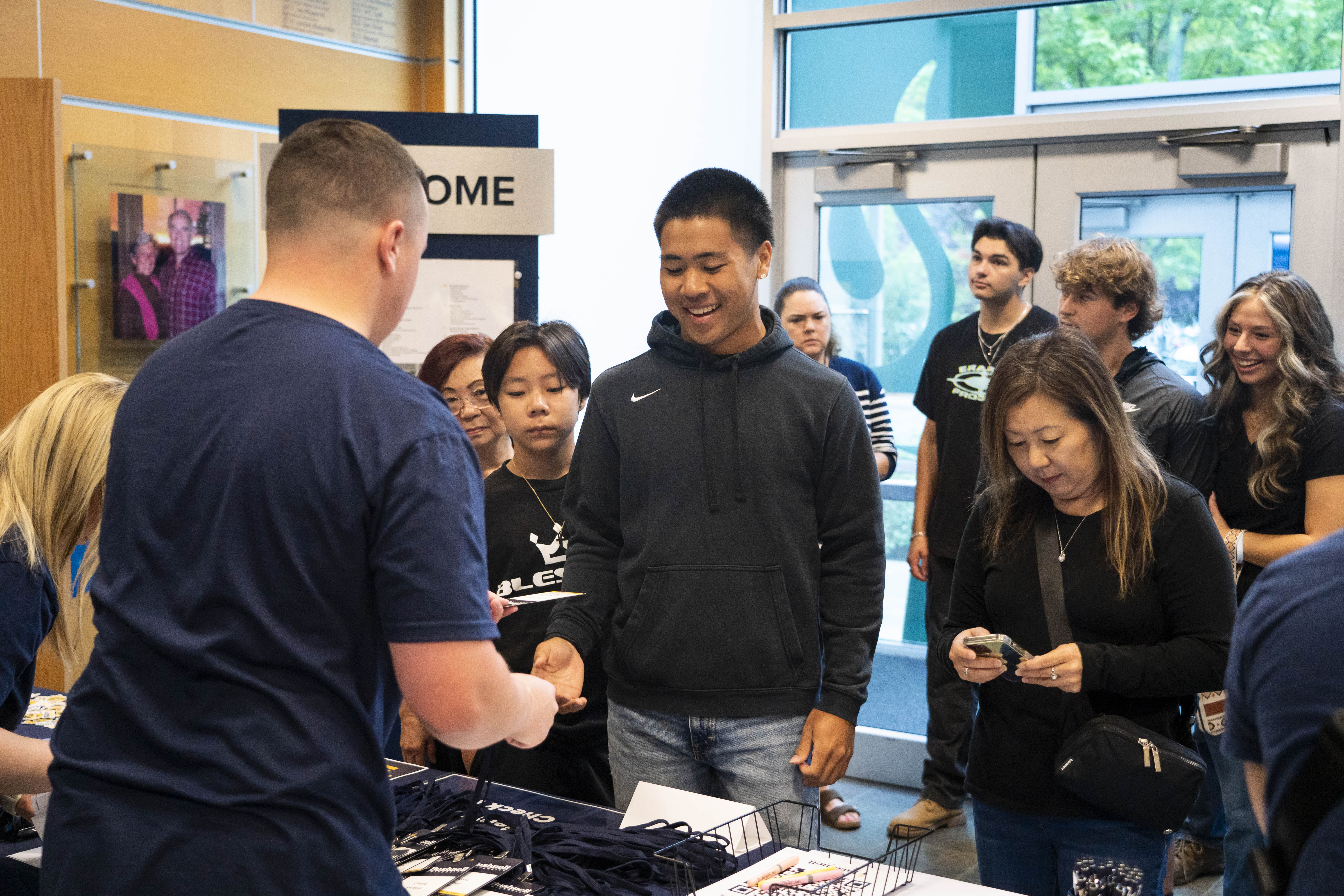 A new student and their family at Orientation receive help from Bushnell University staff at new student check-in.