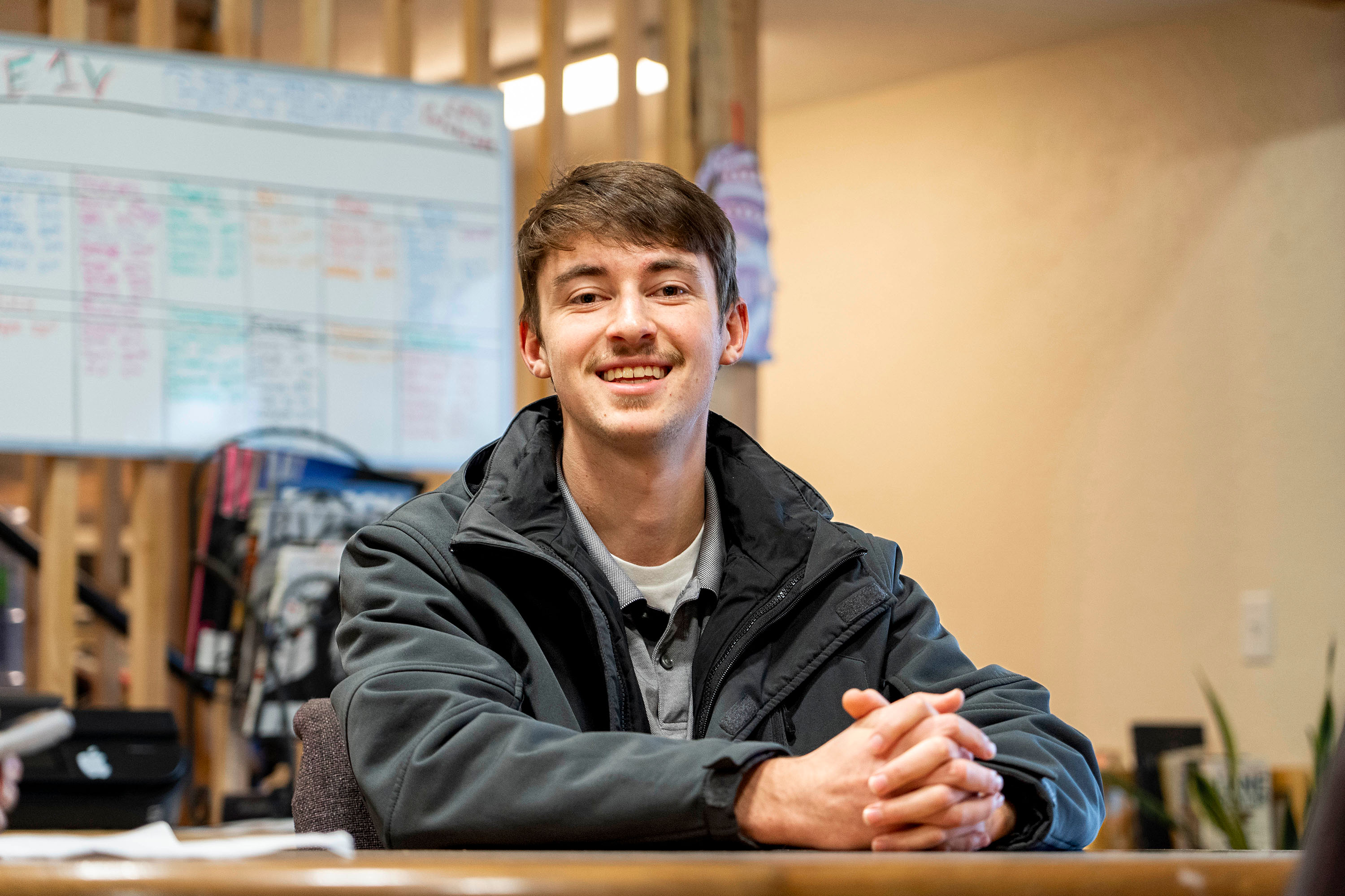 Bushnell student sits at table with hands folded during a meeting for their non-profit internship.