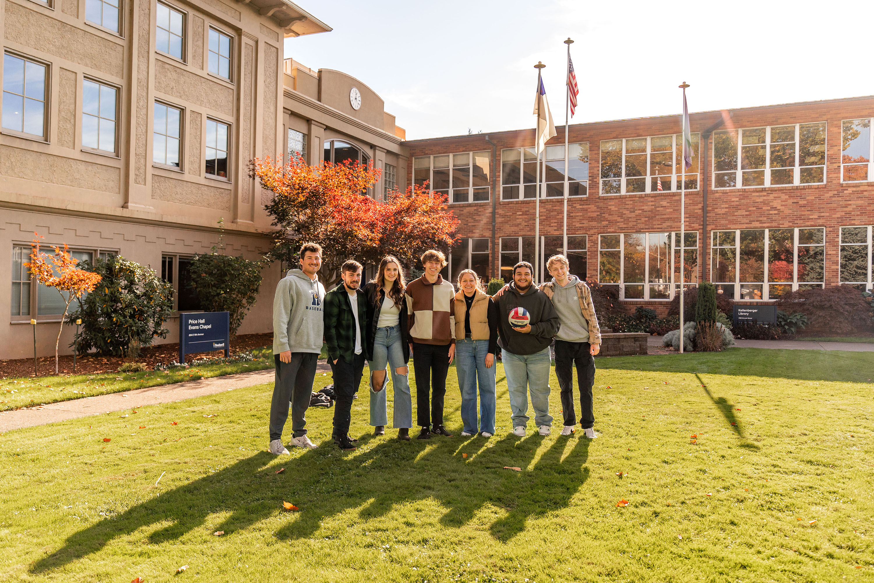 Students standing together in the Bushnell campus Quad on the grass in the evening.