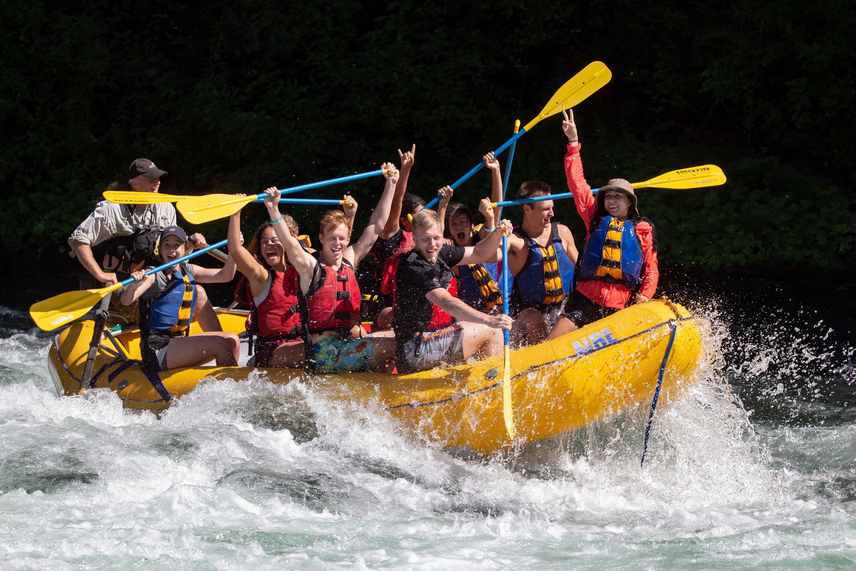 Students cheering while rafting on the New Student Orientation rafting trip.