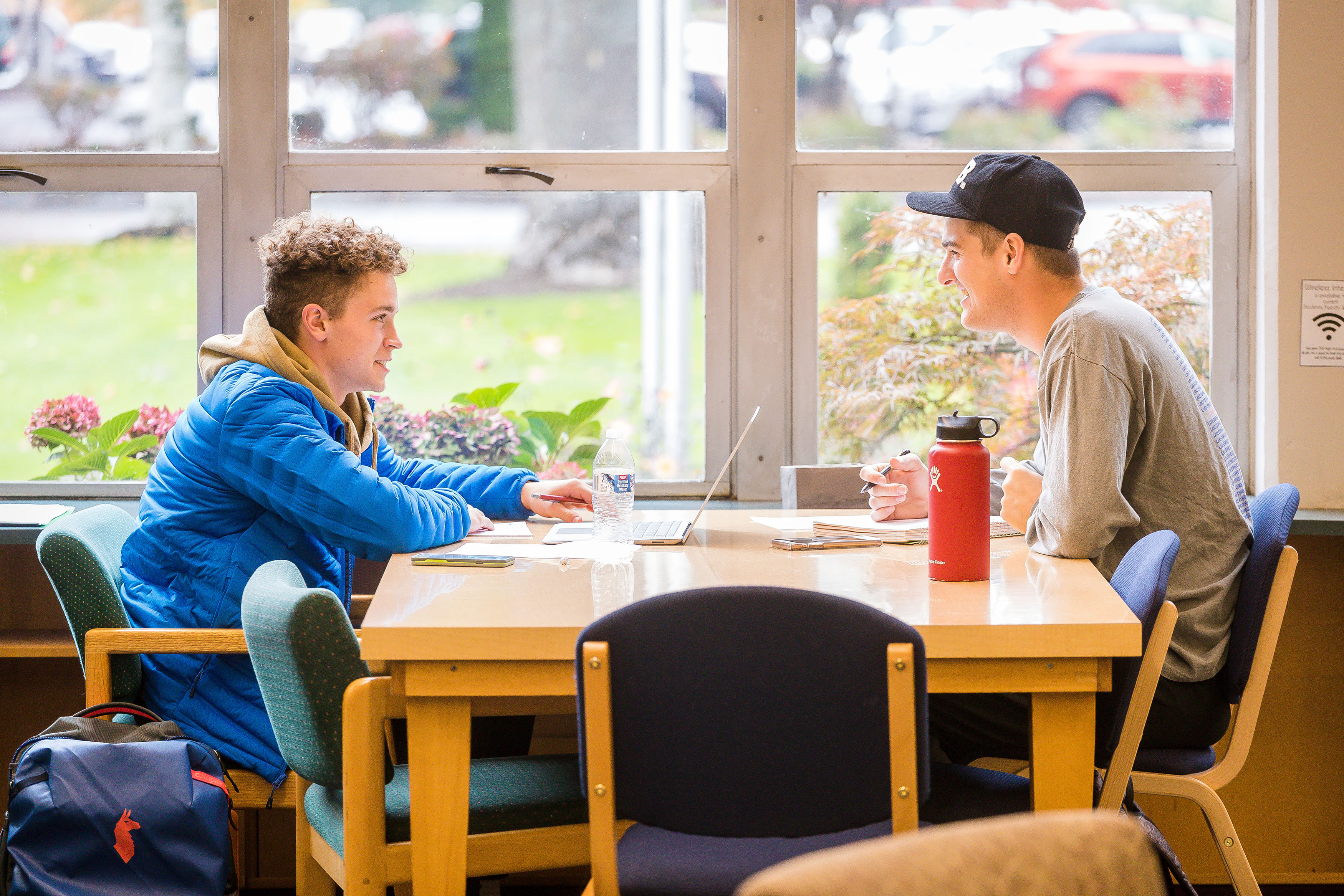 Student tutor works with fellow student in library.