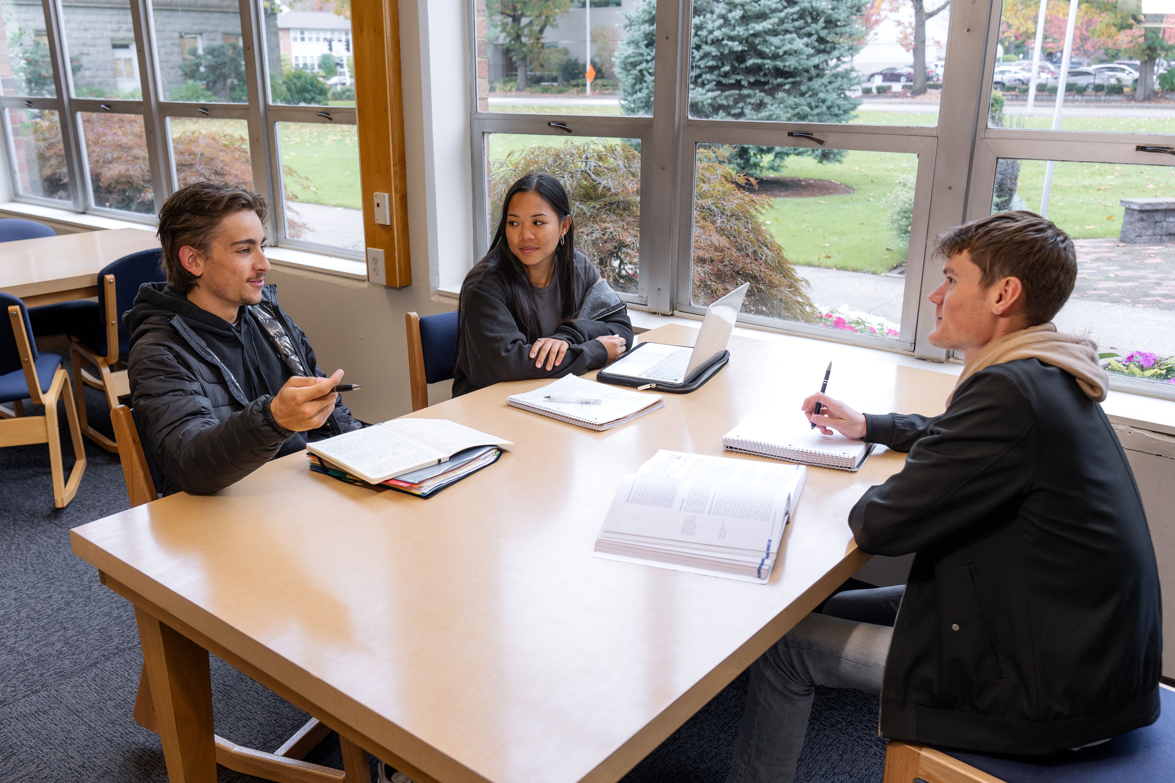 Students in the Bushnell University library talk about their classes while studying.