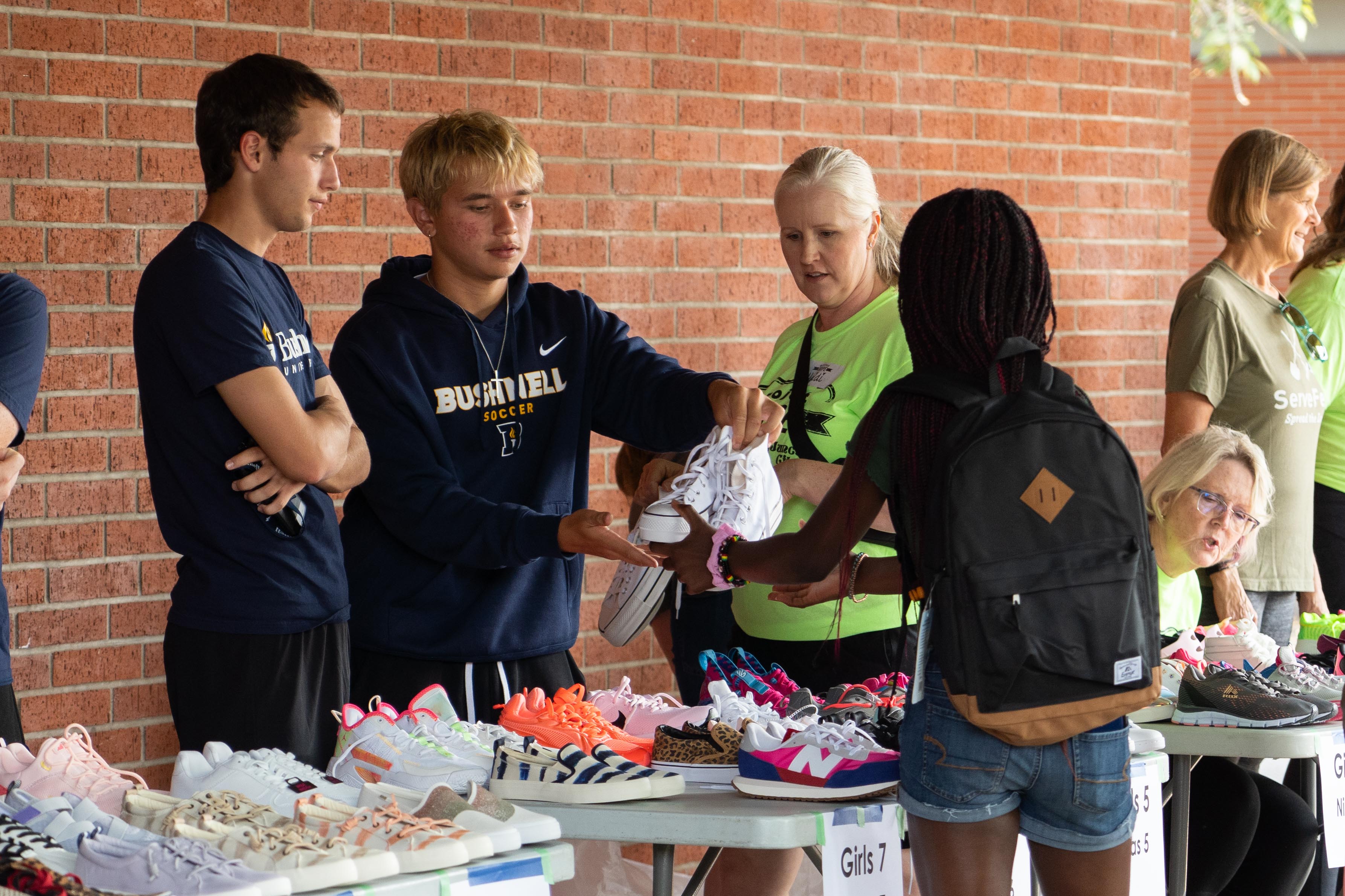 Bushnell University students help distribute shoes to community members during a local outreach event.