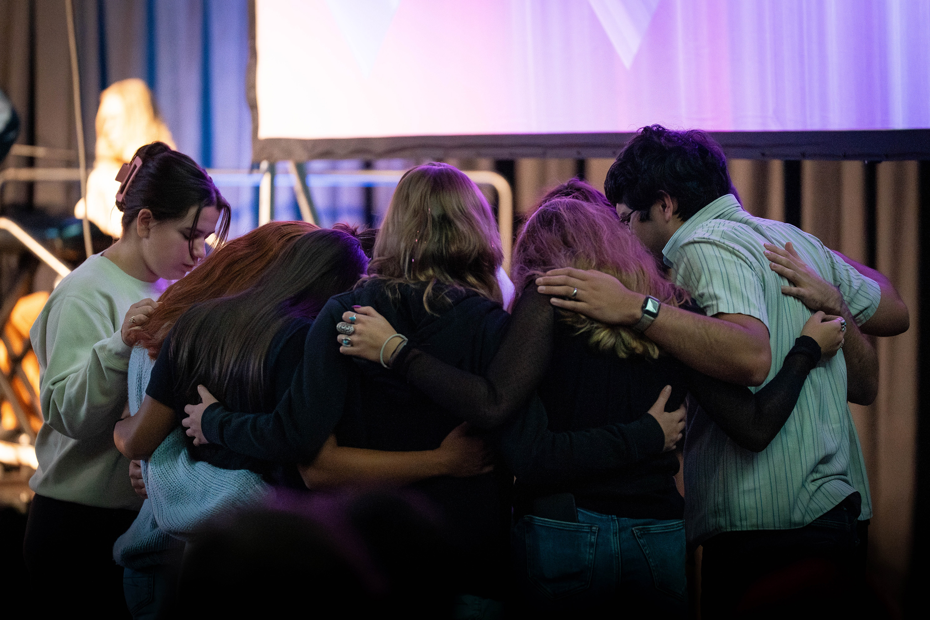 Bushnell University students gather in a circle to pray together during a campus chapel service.