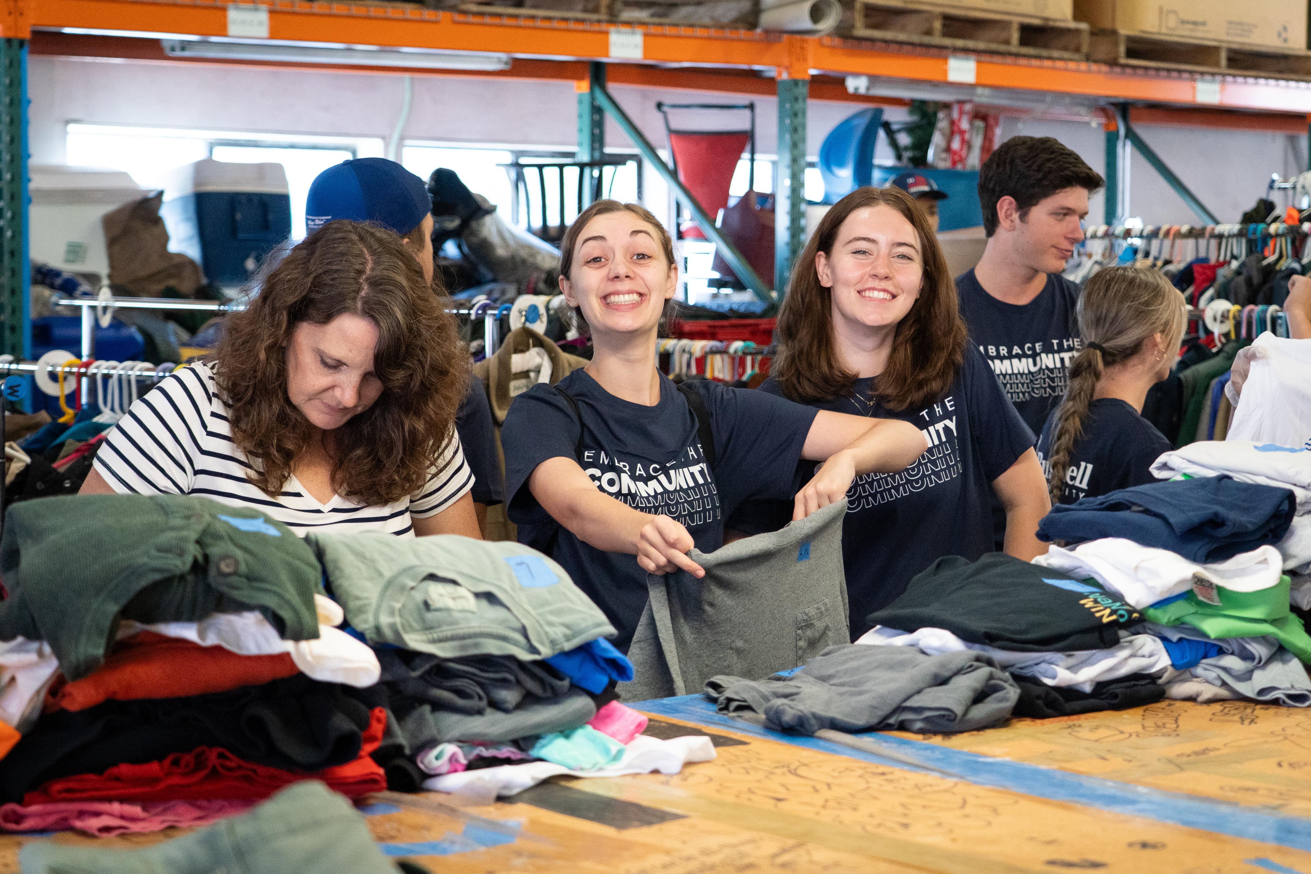Bushnell University students and faculty member sort donated clothing while volunteering at a community outreach organization.