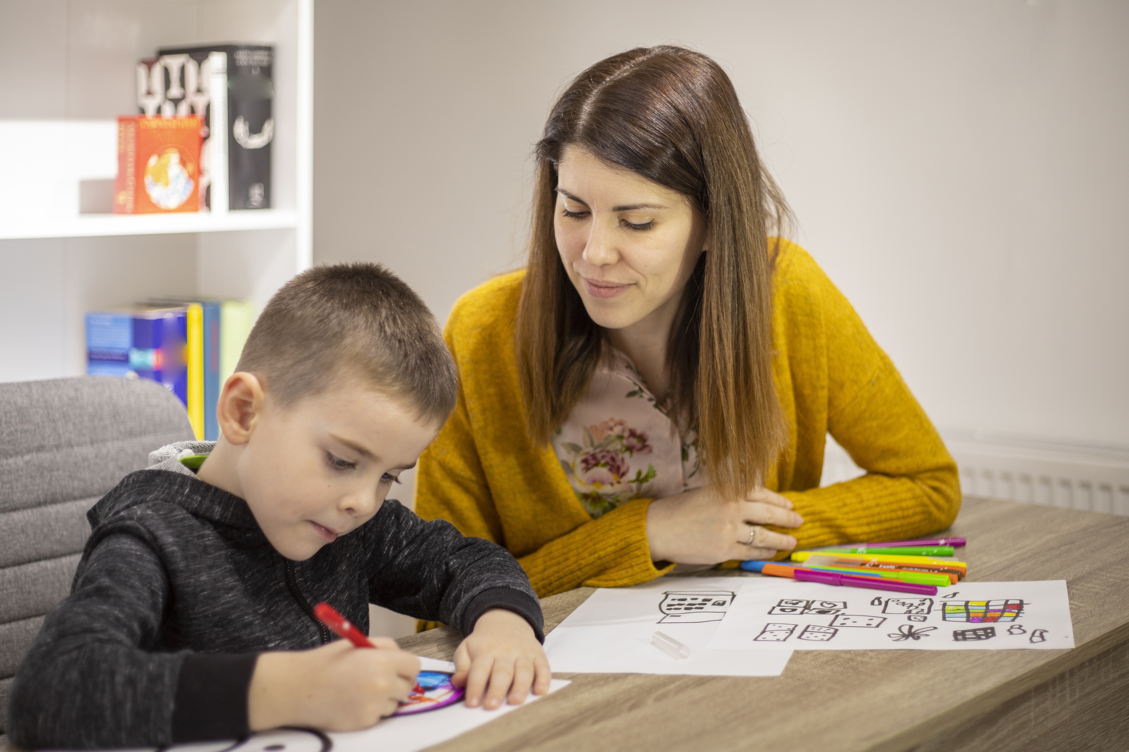 Teacher working one-on-one with an elementary student during a learning activity.