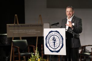 Bushnell University President Joseph Womack speaking from a pulpit on stage.