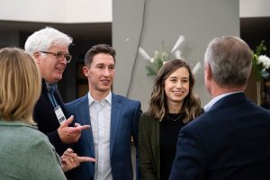 Well dressed event attendees connect with each other.