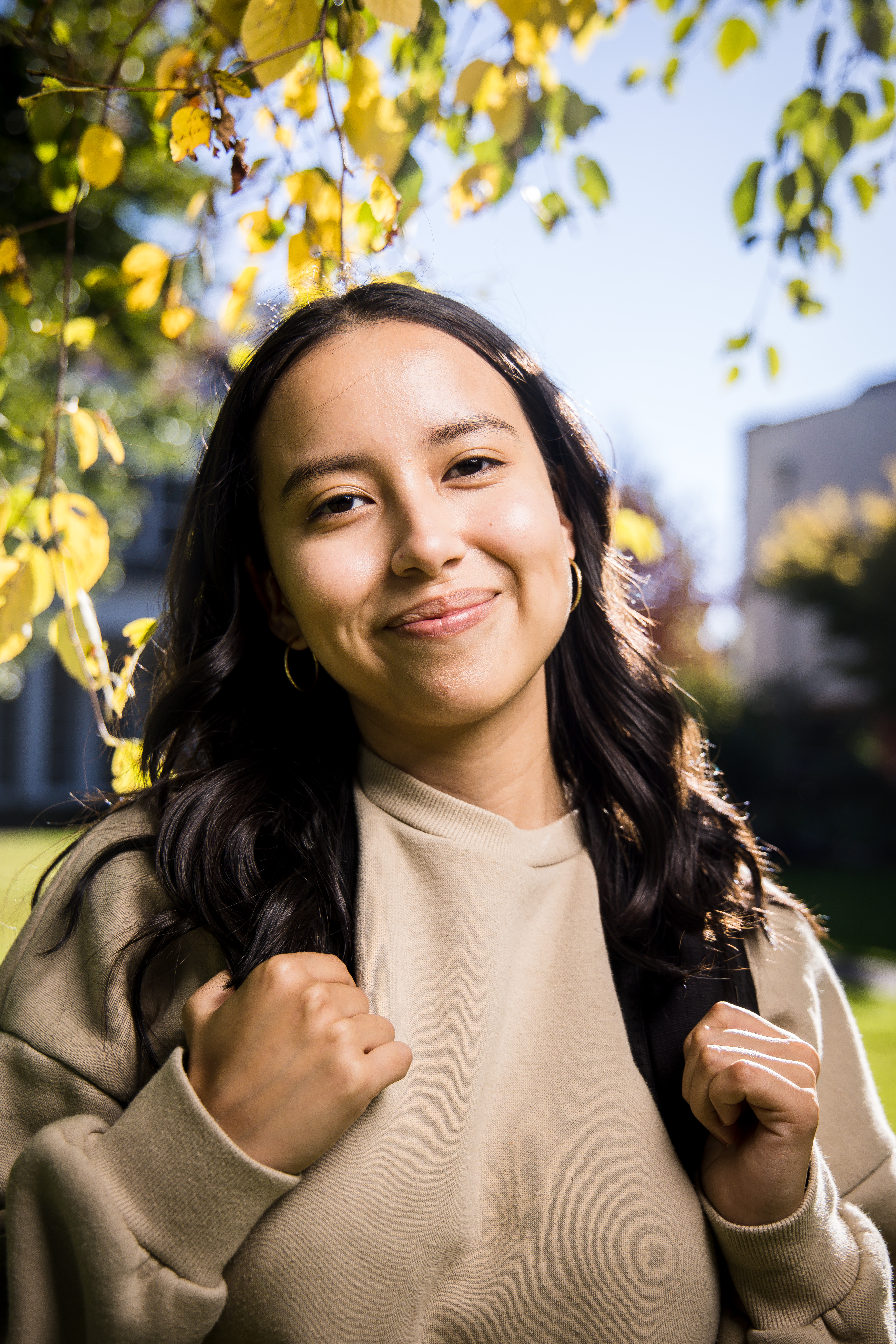 Bushnell University student smiling outdoors on campus with a backpack.