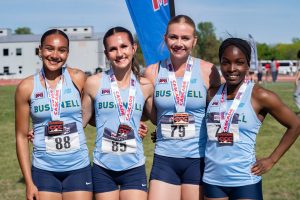 Bushnell Track & Field athletes posing together with medals during an event.