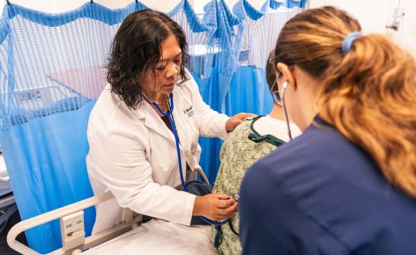 Bushnell faculty member examining a student in a clinical setting