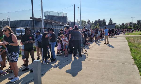 Group of people standing in line at a baseball stadium