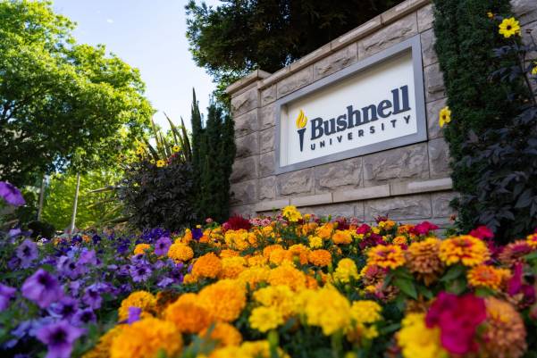 Campus Sign on a sunny day next to flowers