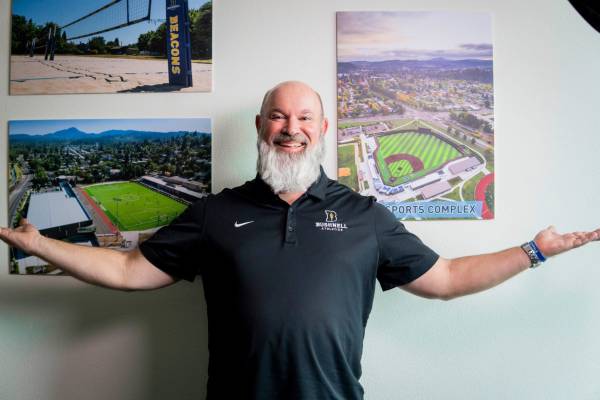 A person with his arms stretched out in front of sports posters