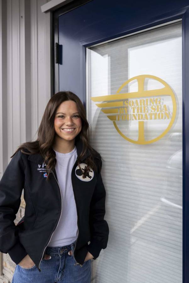 Female student standing outside in front of a sign at internship