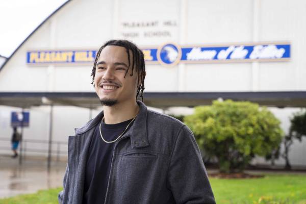 Male student standing outside in front of gym